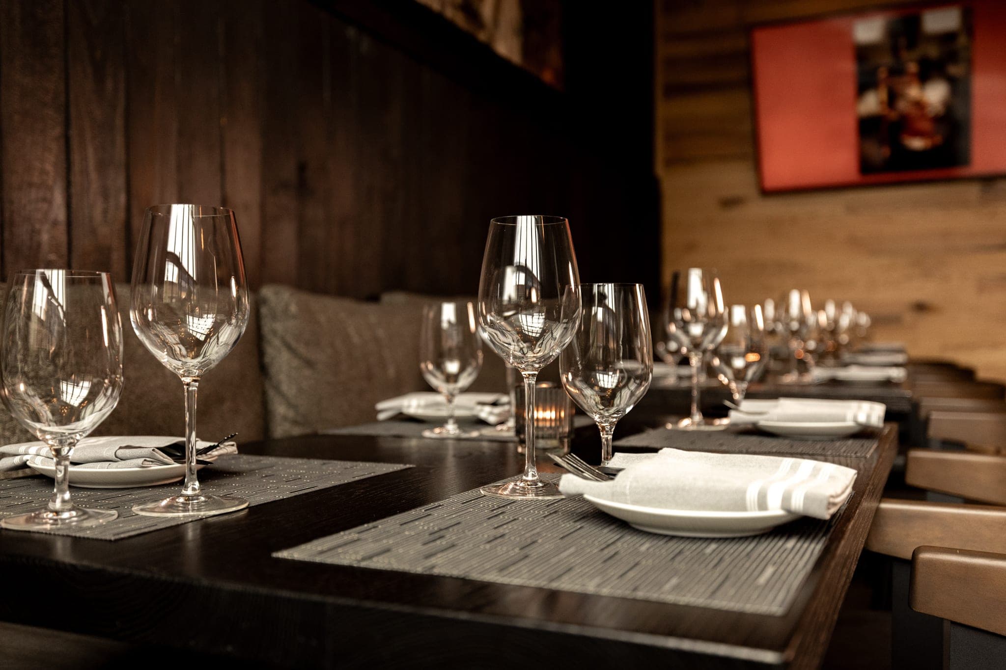 Place settings and glassware lined along the banquette in the CHR Steak private dining room