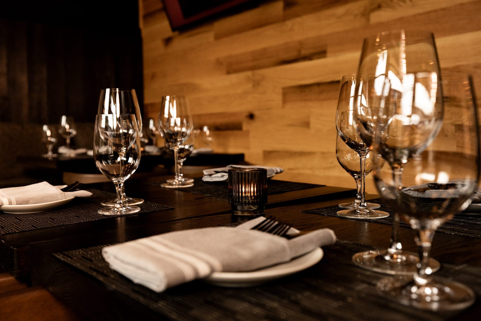 Candlelit table setting with wine glasses in the private dining room at CHR Steak