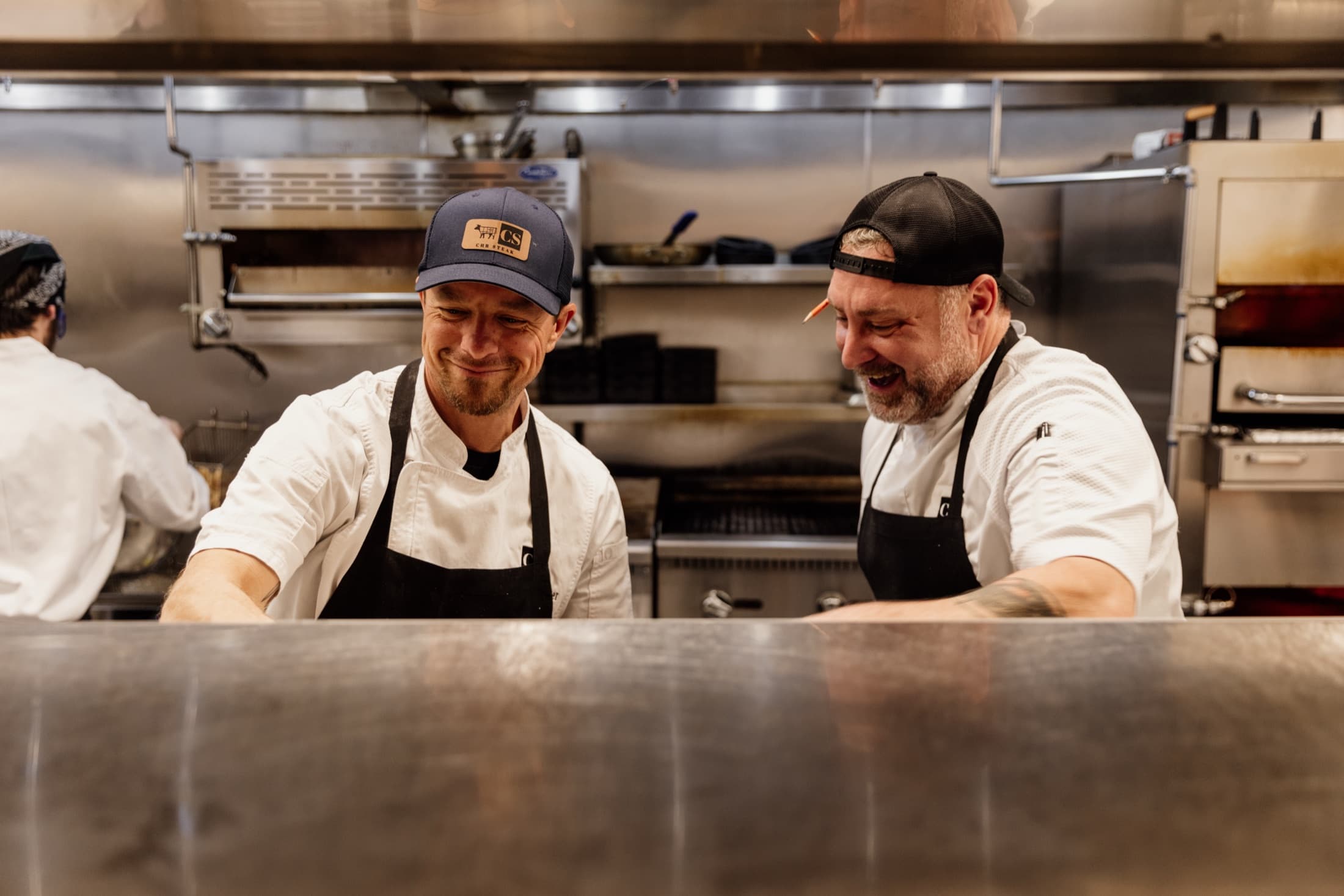 CHR Steak chefs preparing dry-aged steaks on the line in the kitchen